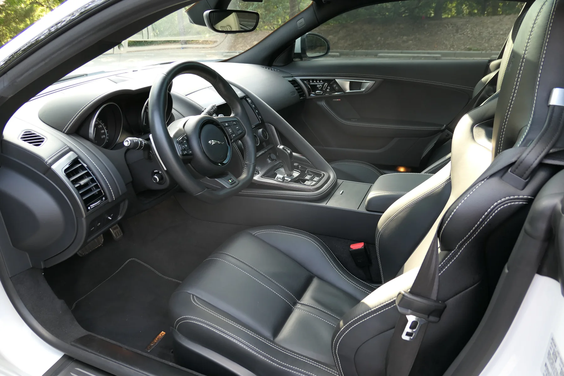 Driver cockpit with steering wheel, center console and performance seat