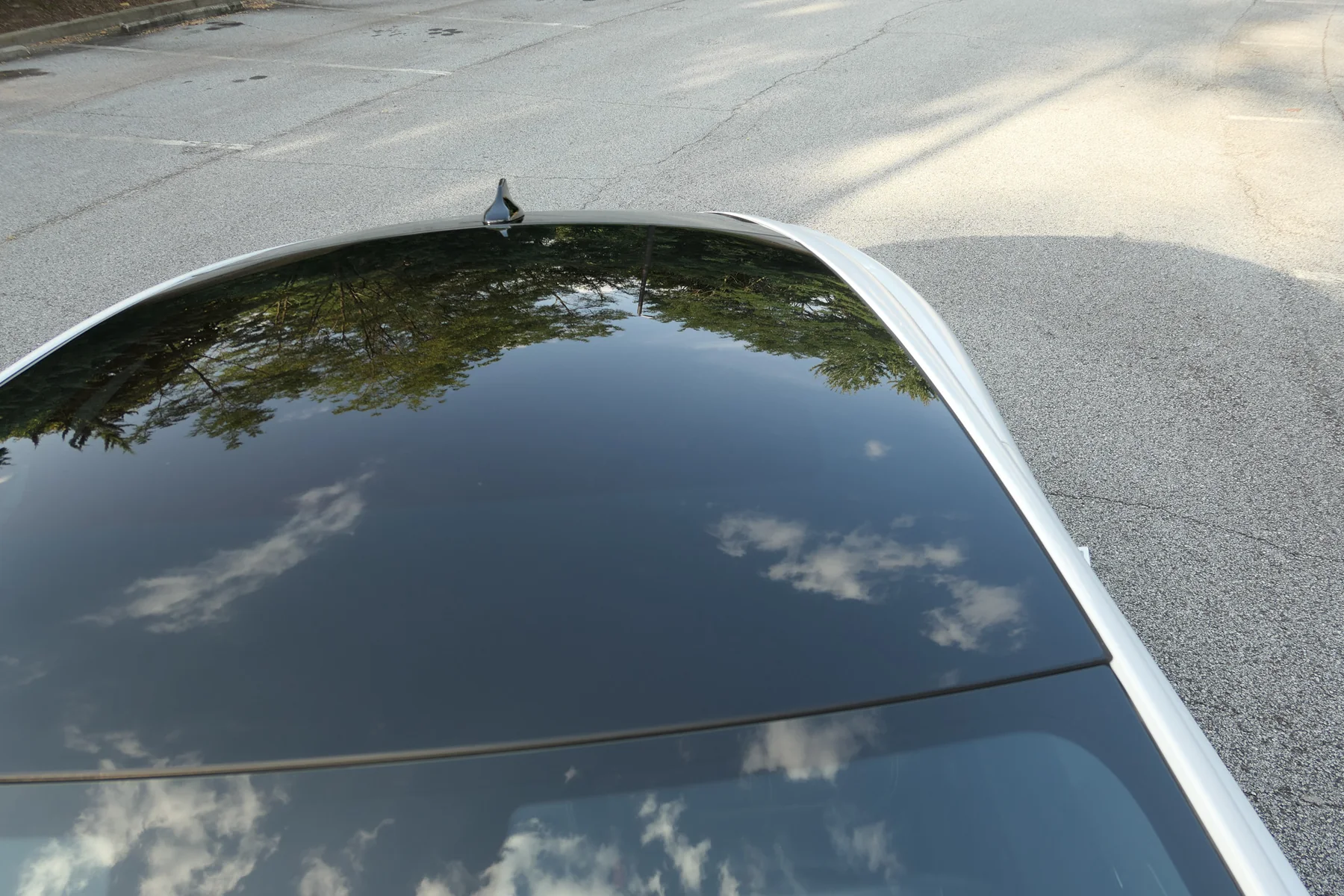 Black panoramic glass roof reflecting the sky